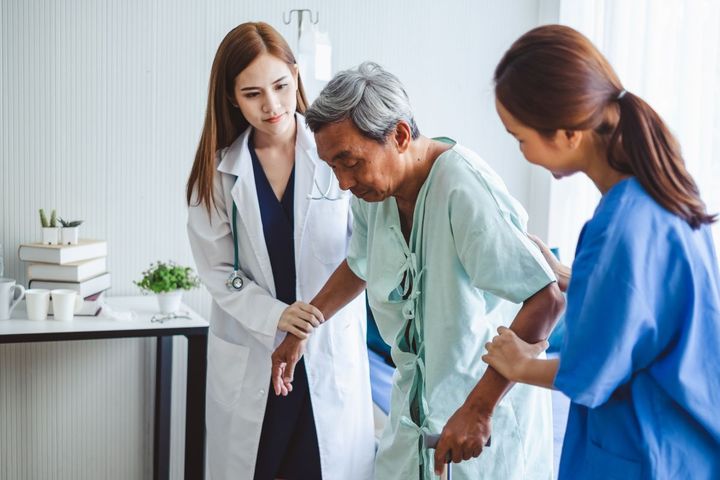 A physician and a nurse providing clinical care to a patient.