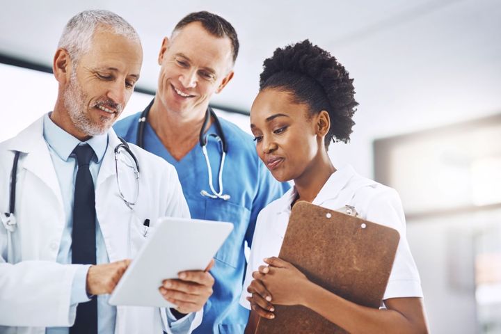 A manager at a hospital meets with a physician and nurse.