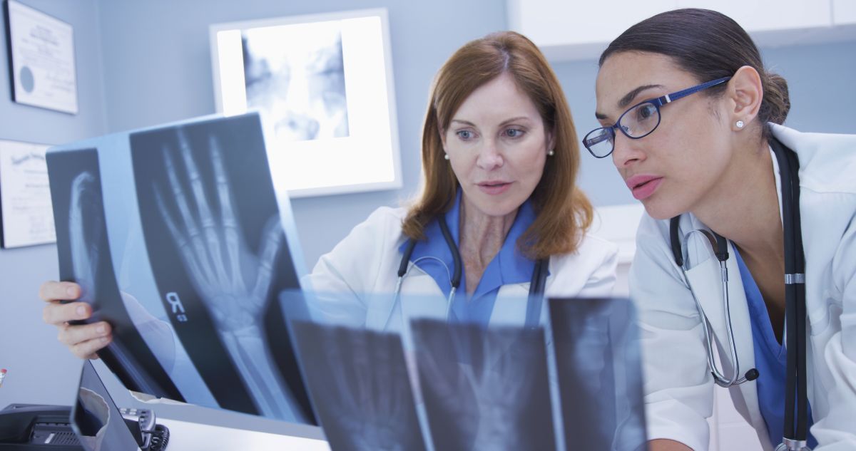 A physician assistant and her supervising physician go over a patient's X-rays.