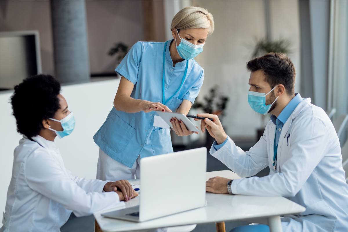A nurse with CCNS certification leads a meeting in a hospital.