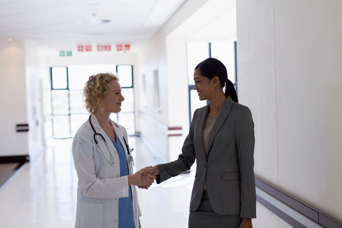 A clinic's chief ambulatory officer shakes the hand of one of the senior physicians.