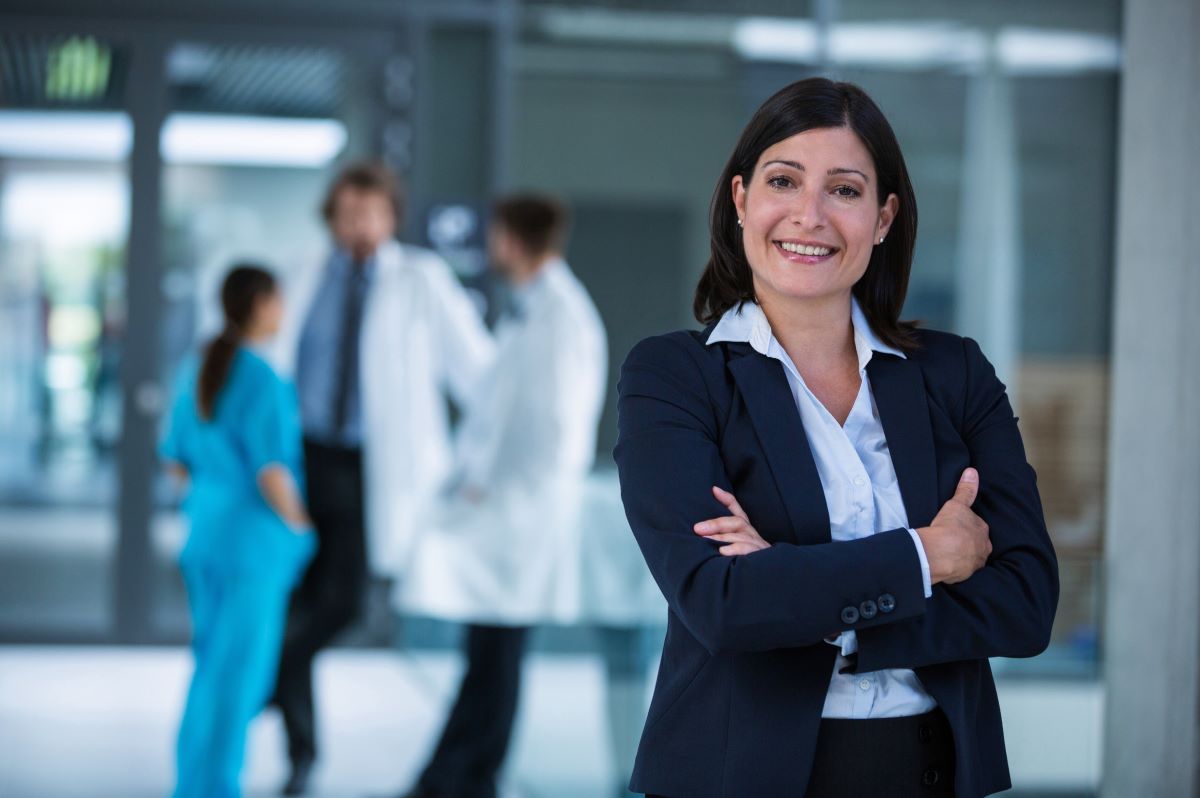 A hospital's chief financial officer stands in the hallway and smiles.