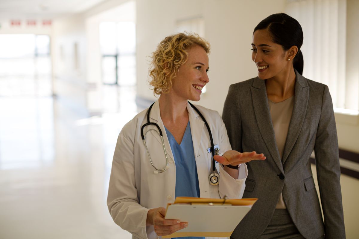 A chief listening officer listens to feedback from a charge nurse.