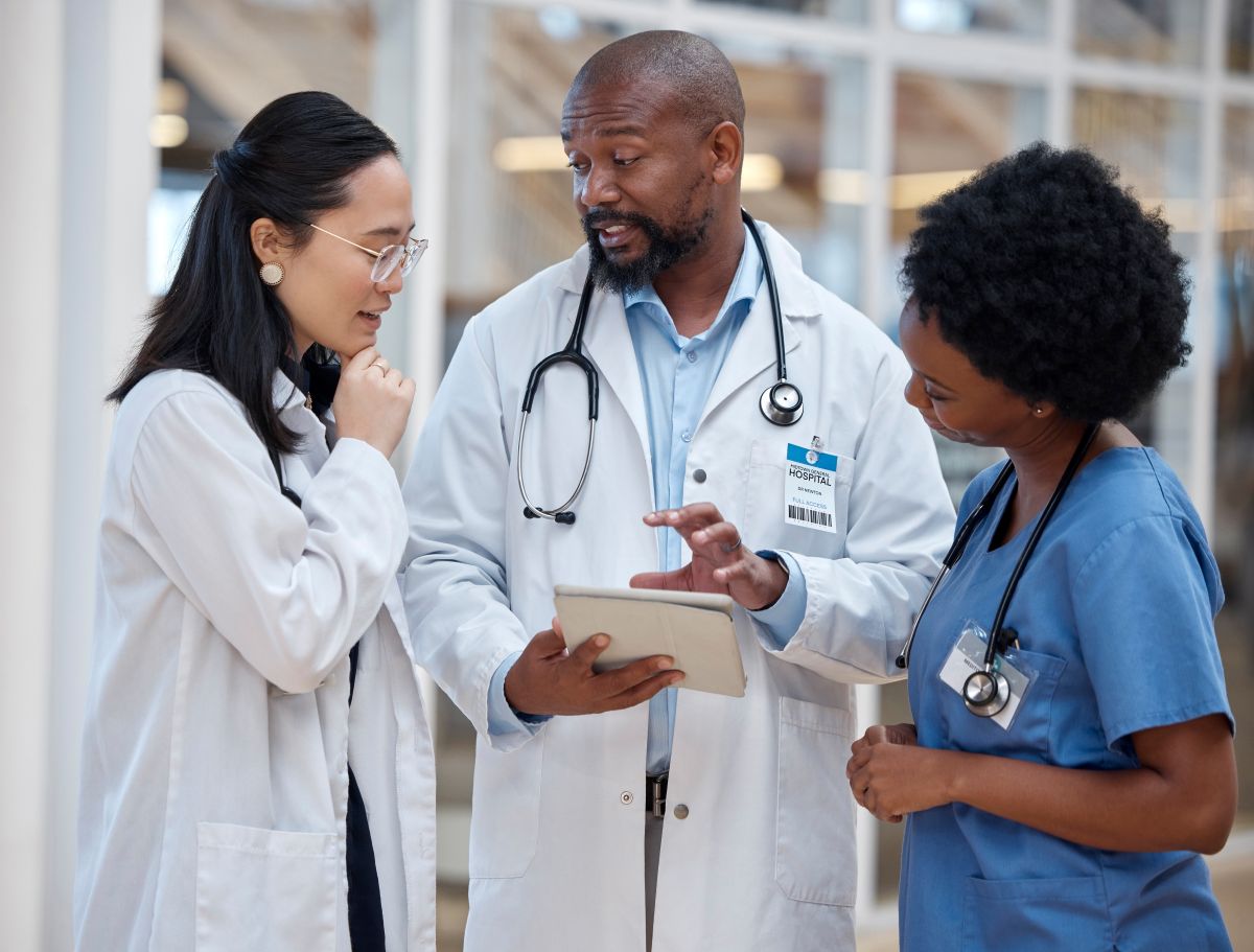 A hospital's clinical operations manager meets with a nurse and a physician.