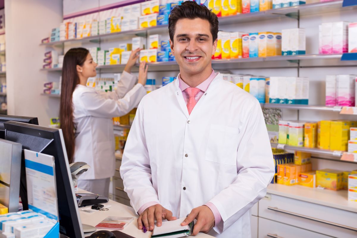 A clinical pharmacist stands at a monitor.