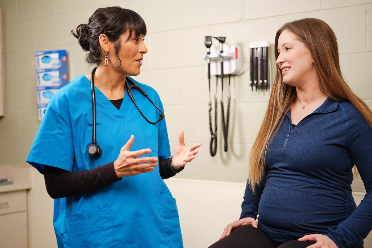 A nursing professional uses CNA tips from their education while speaking with a patient.