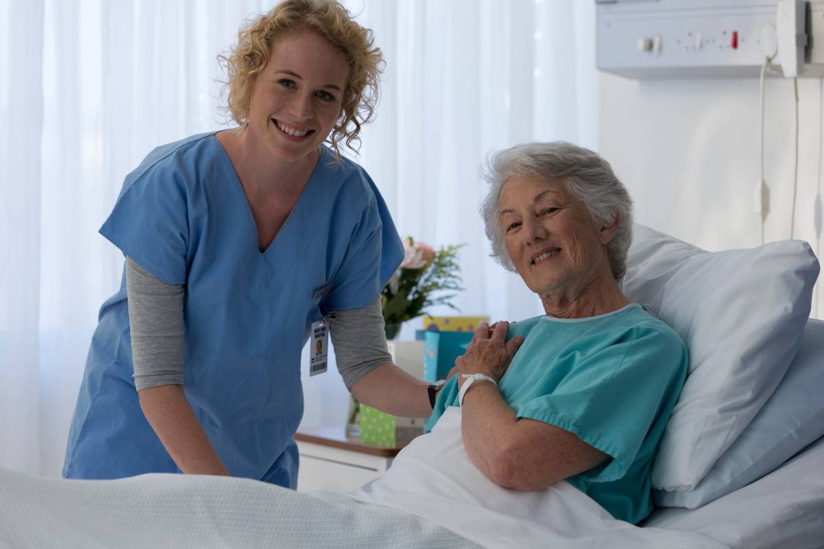 A nurse with CNN certification assists a patient in a hospital room.