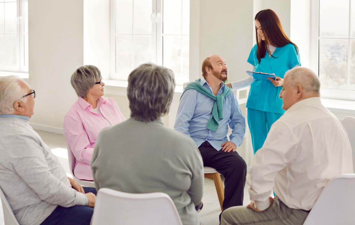 A community health nurse meets with seniors at a long term care facility.
