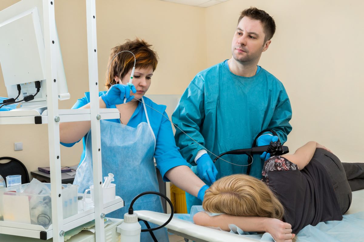 Two endoscopy nurses prep a patient for a procedure.