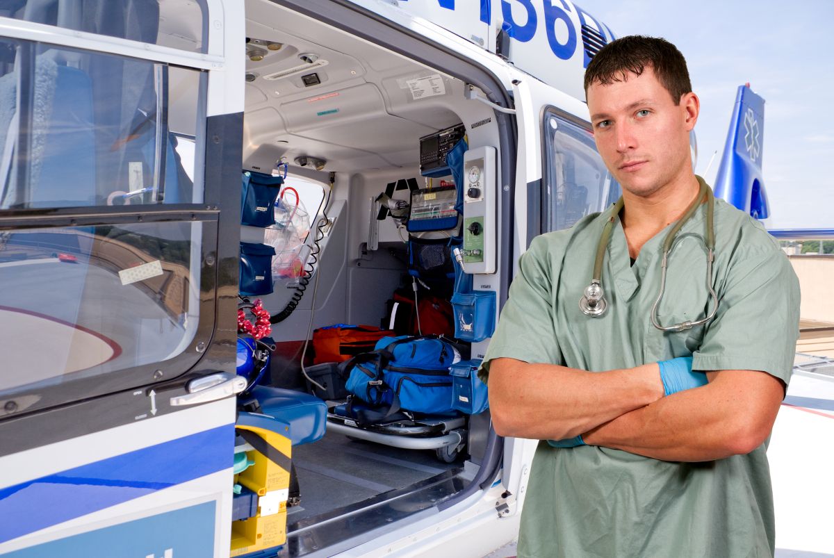 A flight nurse stands outside his helicopter.