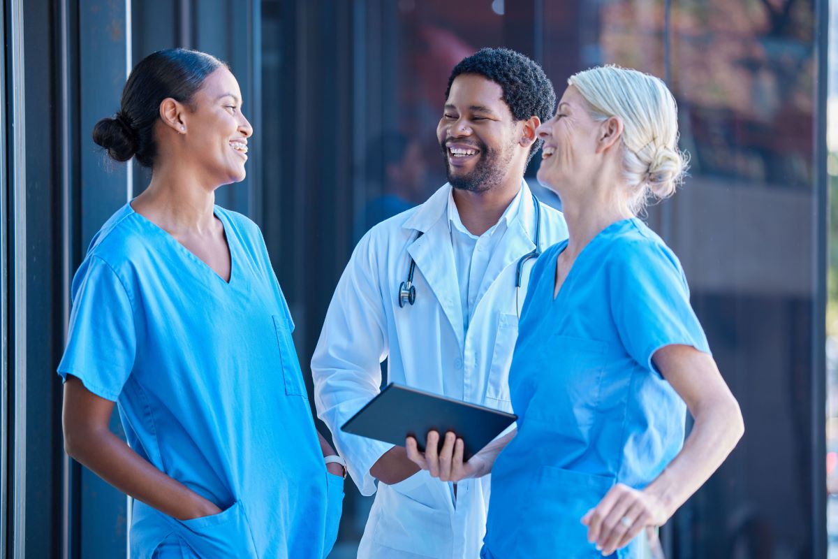 A couple of nurses share a moment with a physician.