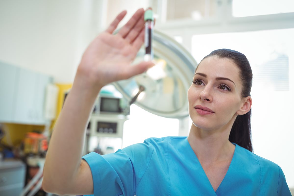 A forensic nurse looks at a sample in the lab.