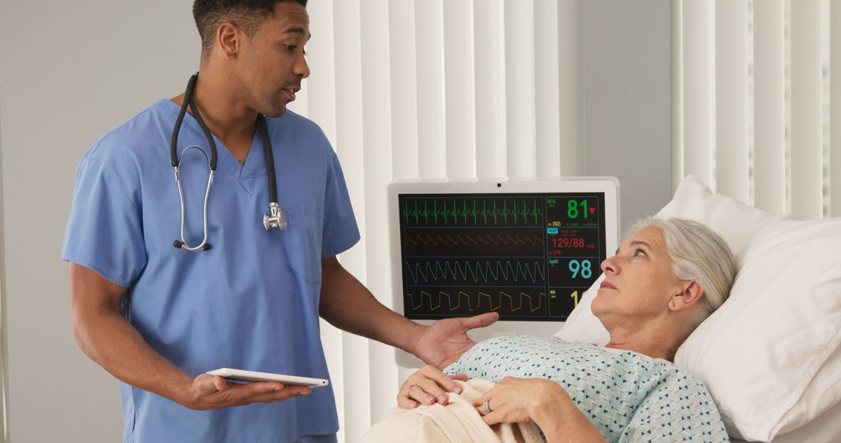 A nurse consults with a patient, teaching her the basics of the health triangle.