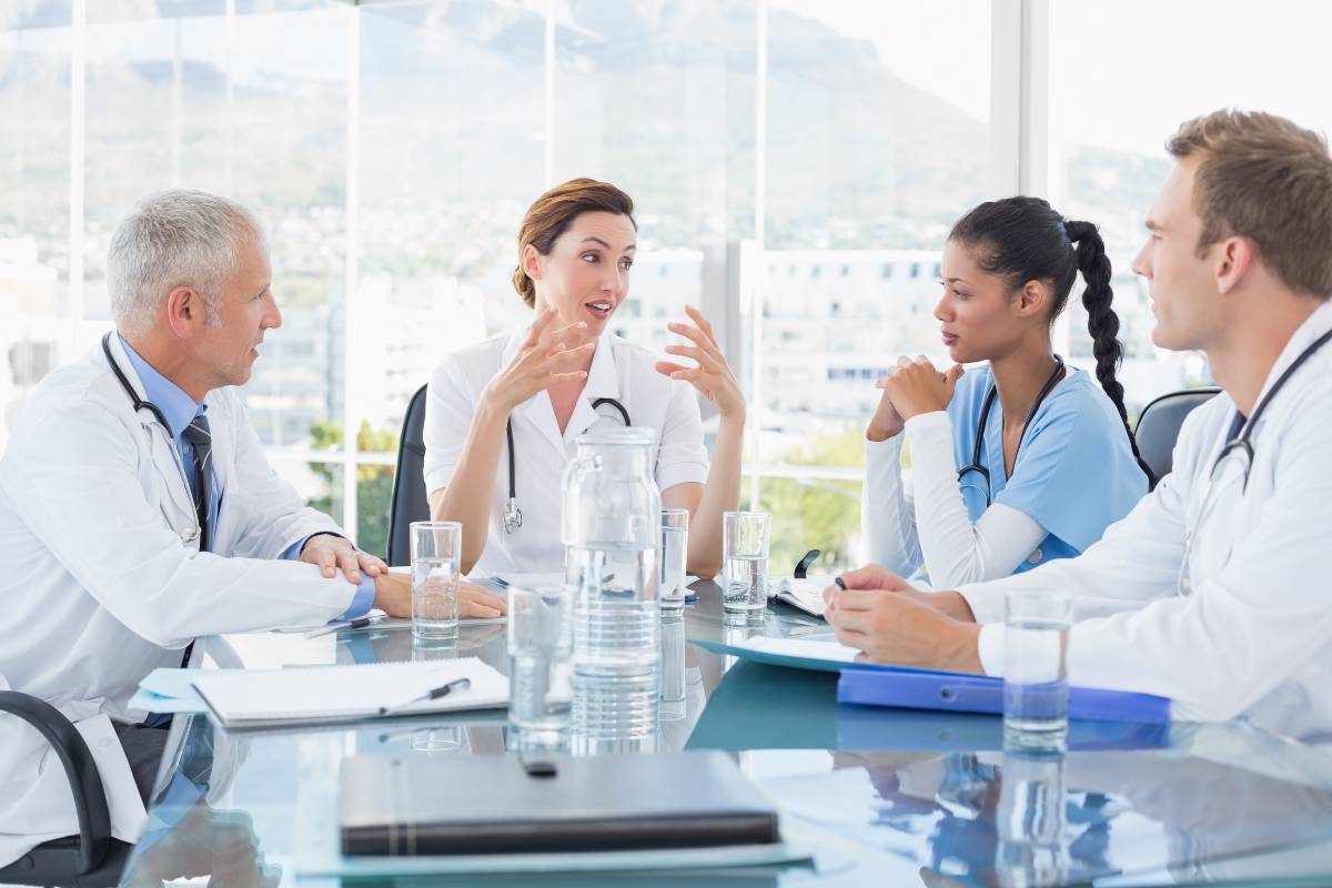 A nurse practices healthcare advocacy during a meeting with hospital leadership.