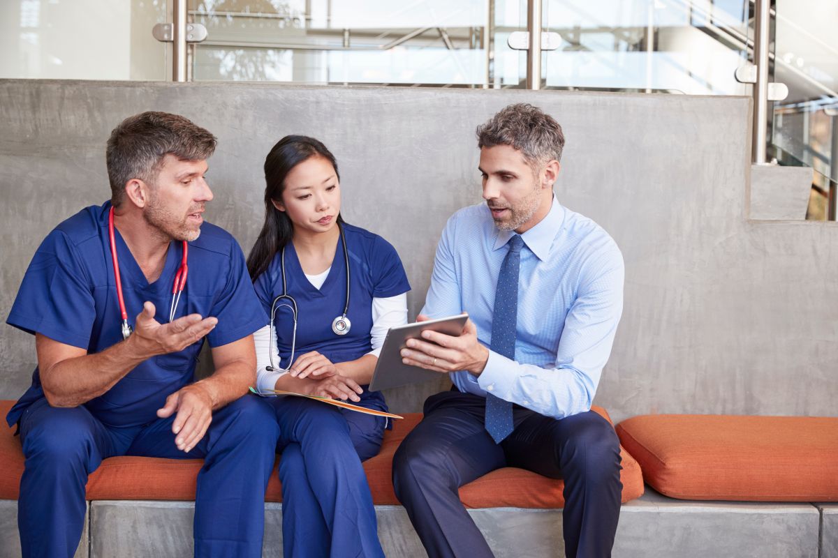 Two nurses discuss ways to respond to a healthcare cyber attack with their IT consultant.