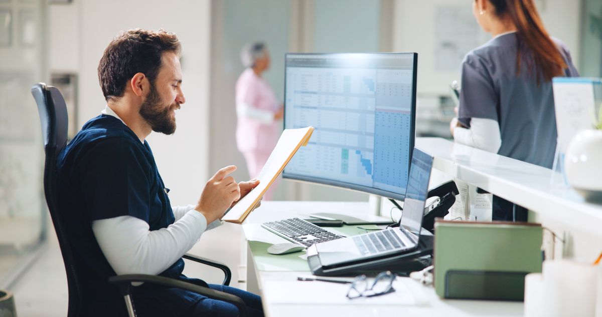 A nurse follows best practices for healthcare cybersecurity as he reviews sensitive documents.