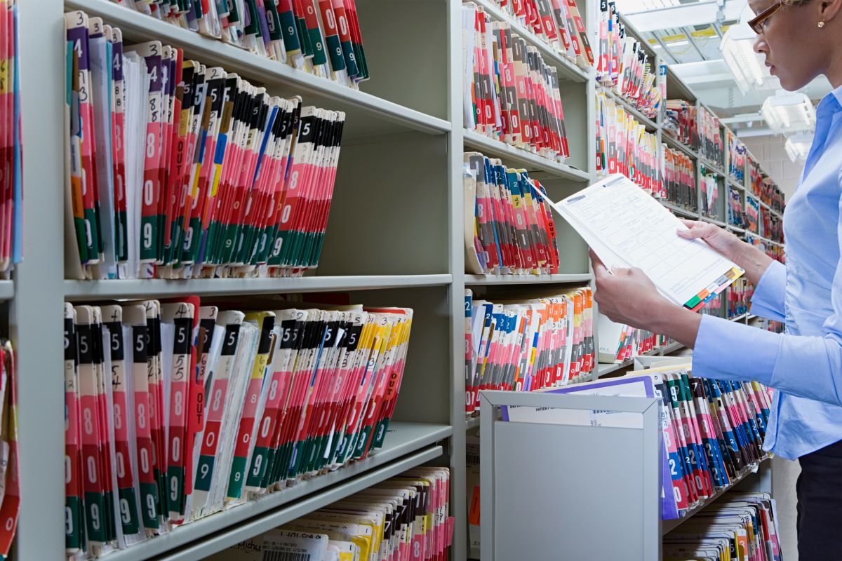 A healthcare administrator checks a patient's file.