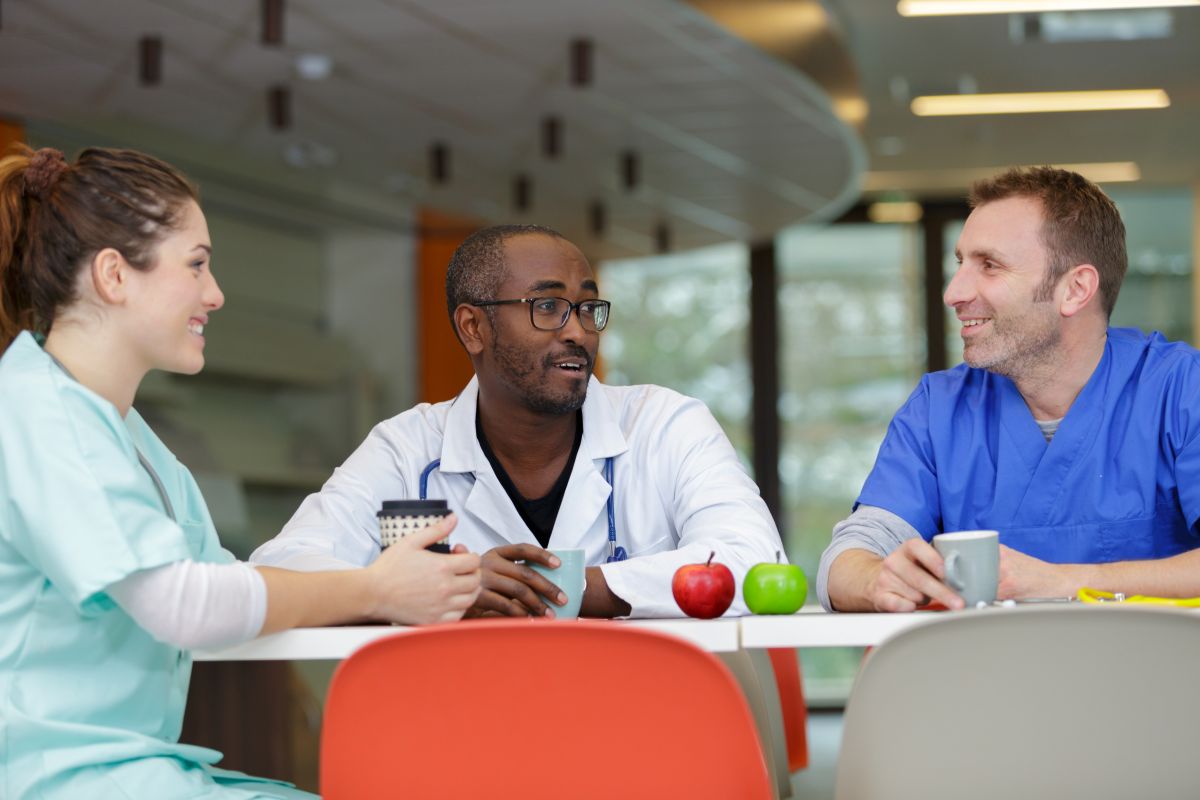 Colleagues gather at a table in the hospital break room.