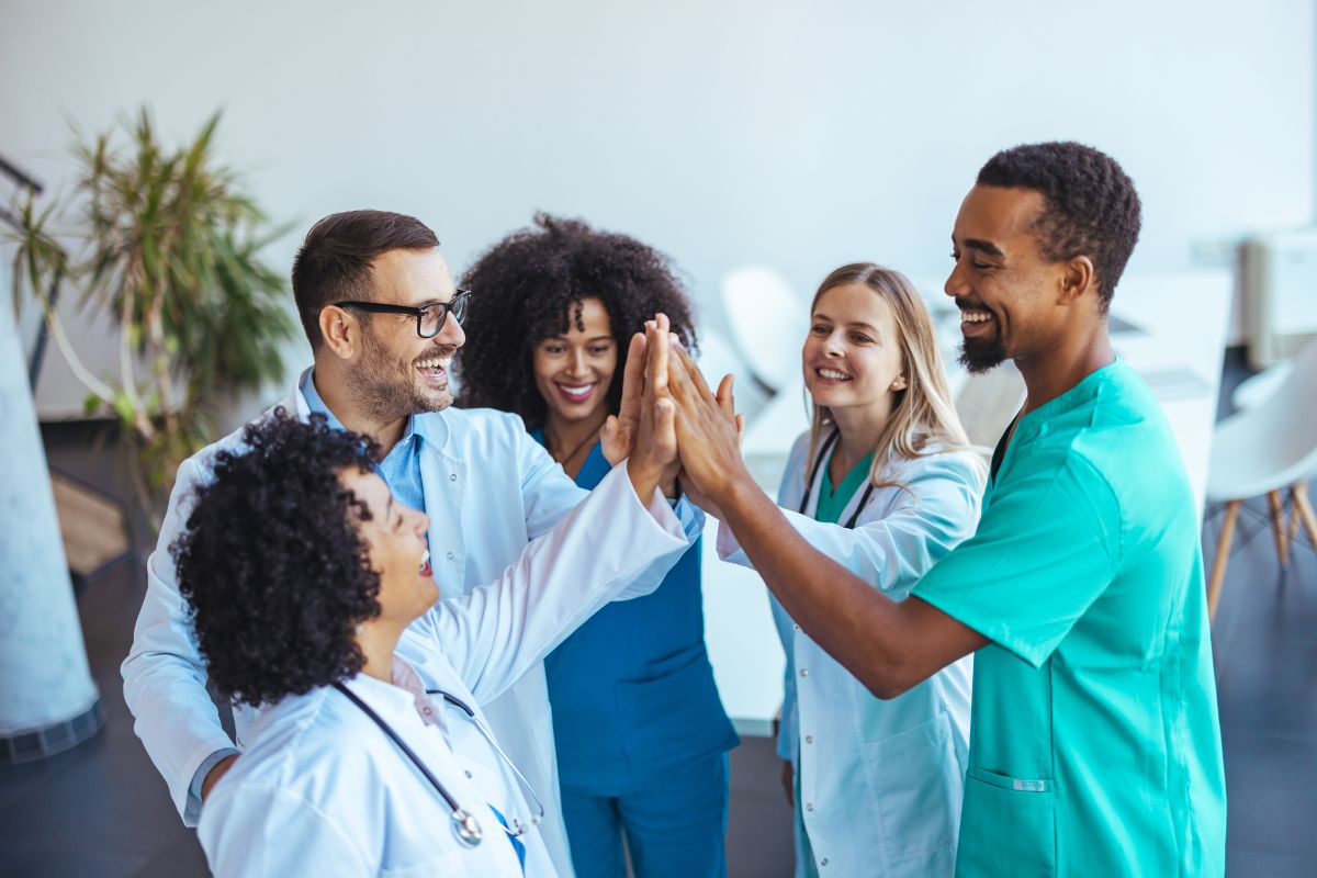 Providers with hospital privileges high-five each other.