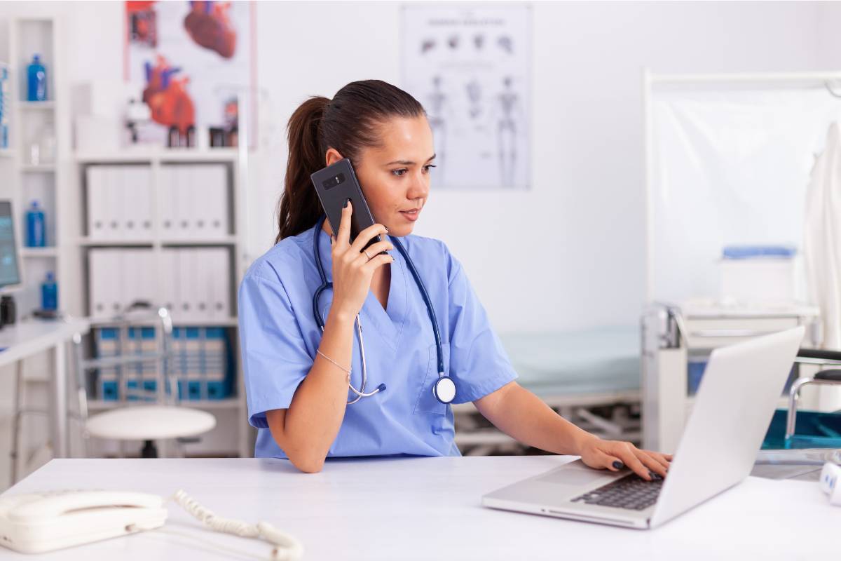 A nurse talks on the phone, discussing how to become an RN in New Jersey.