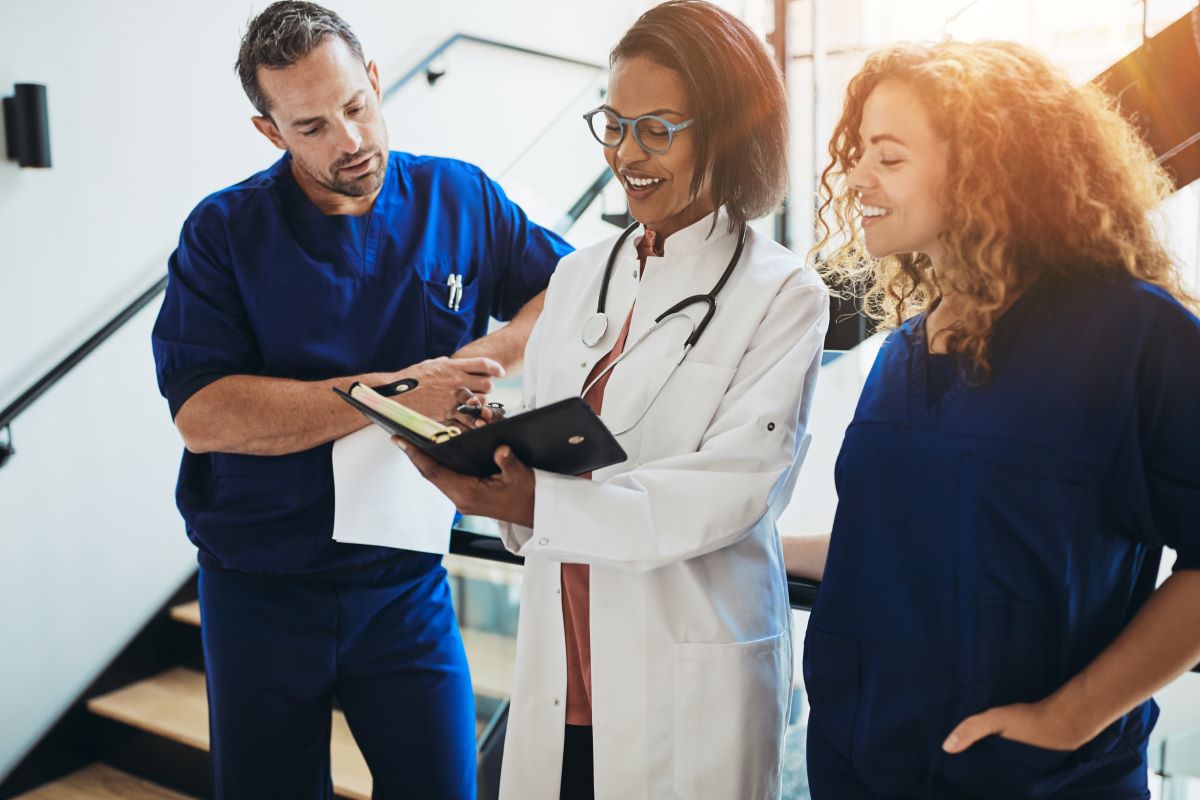 A physician meets with two of her nurses to discuss a treatment plan.