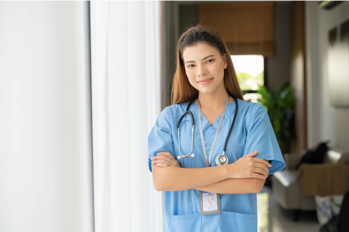 A nurse poses for a photo in a hallway while discussing how to recover from burnout.