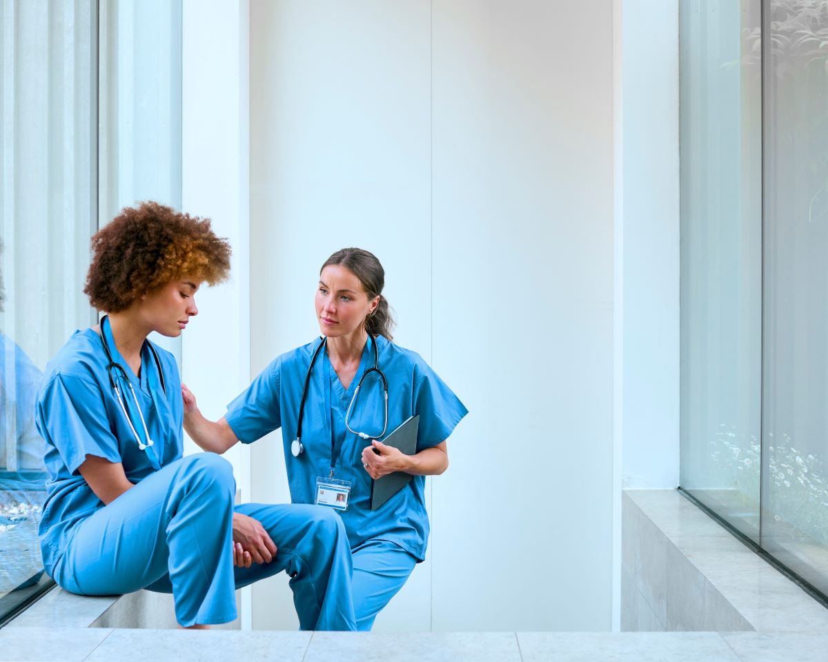 A nurse comforts one of her colleagues who is grieving the loss of a loved one.