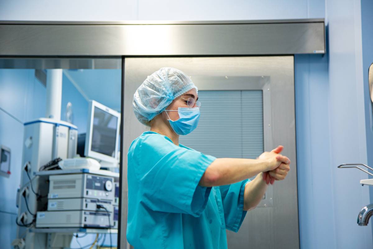 An infection control nurse washes their hands.
