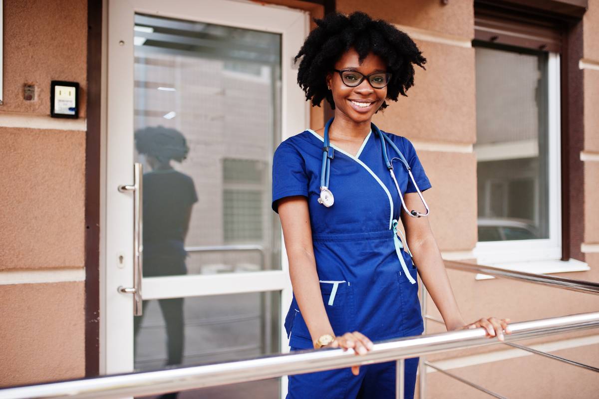 A nurse poses for a photo while reflecting on inspirational nurse sayings from famous nurses.