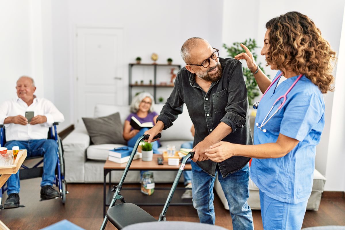 A nurse assists a resident who's using a walker.