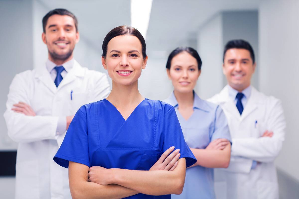 A nurse poses for a photo with colleagues after discussing jobs for an RN with associate degree education.