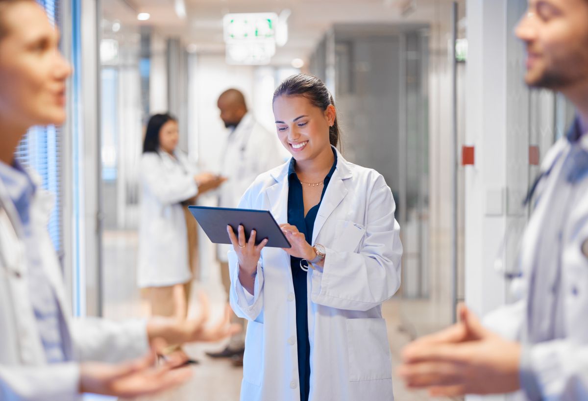 Doctors in a Louisiana medical clinic confer with each other in the hallway, as one looks at a tablet computer.