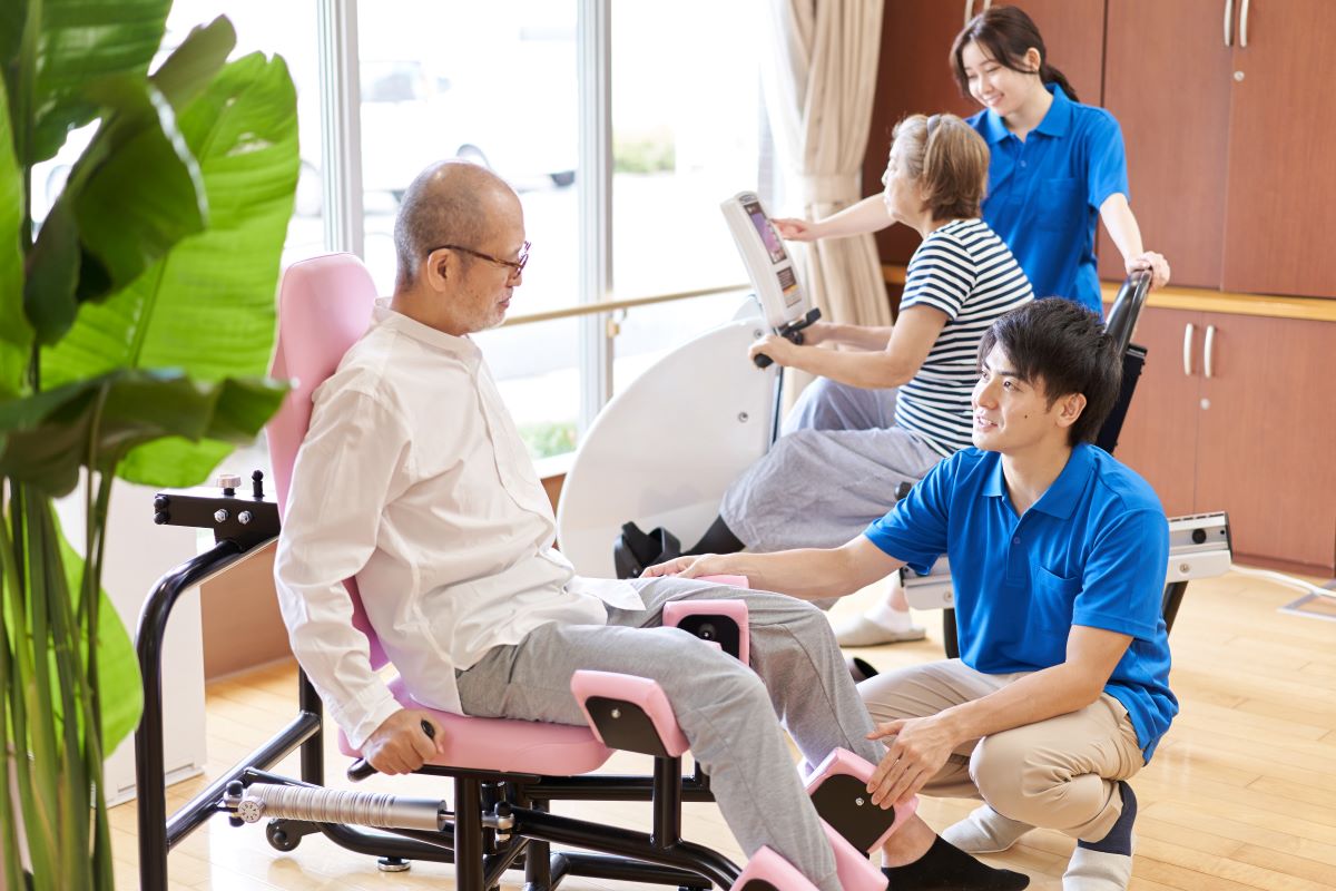 A physical therapist assists one of his patients at a long-term acute care (LTAC) facility.