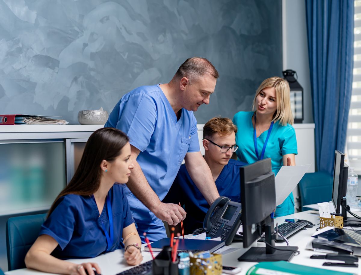 An MDS nurse and his colleagues look over medical records.