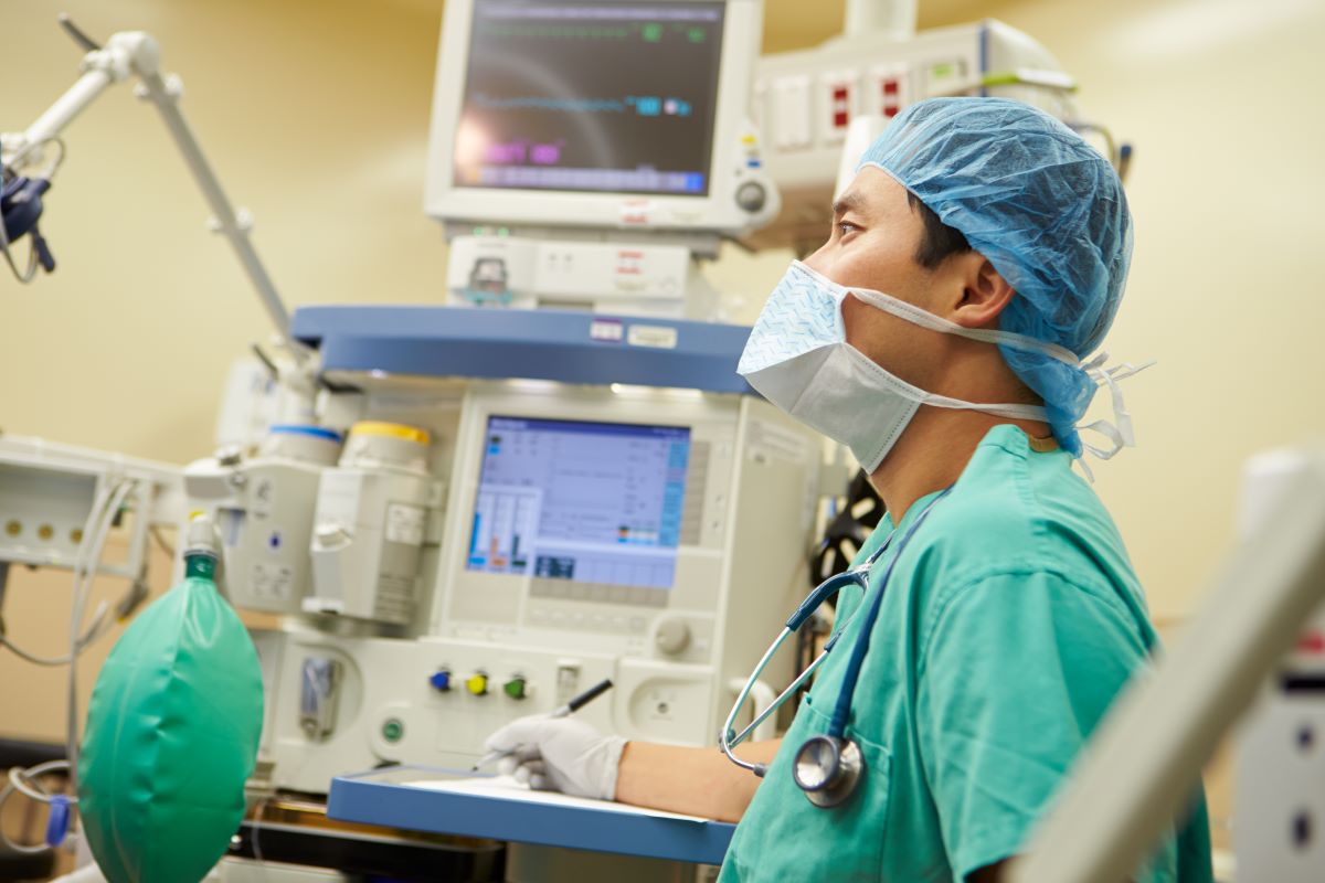 A nurse anesthetist monitors a patient's status during surgery.