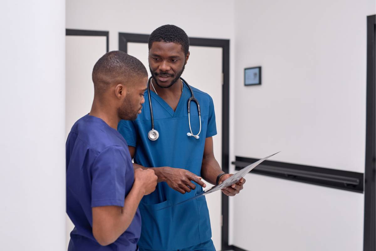 A nurse preceptor explains a concept to his mentee.