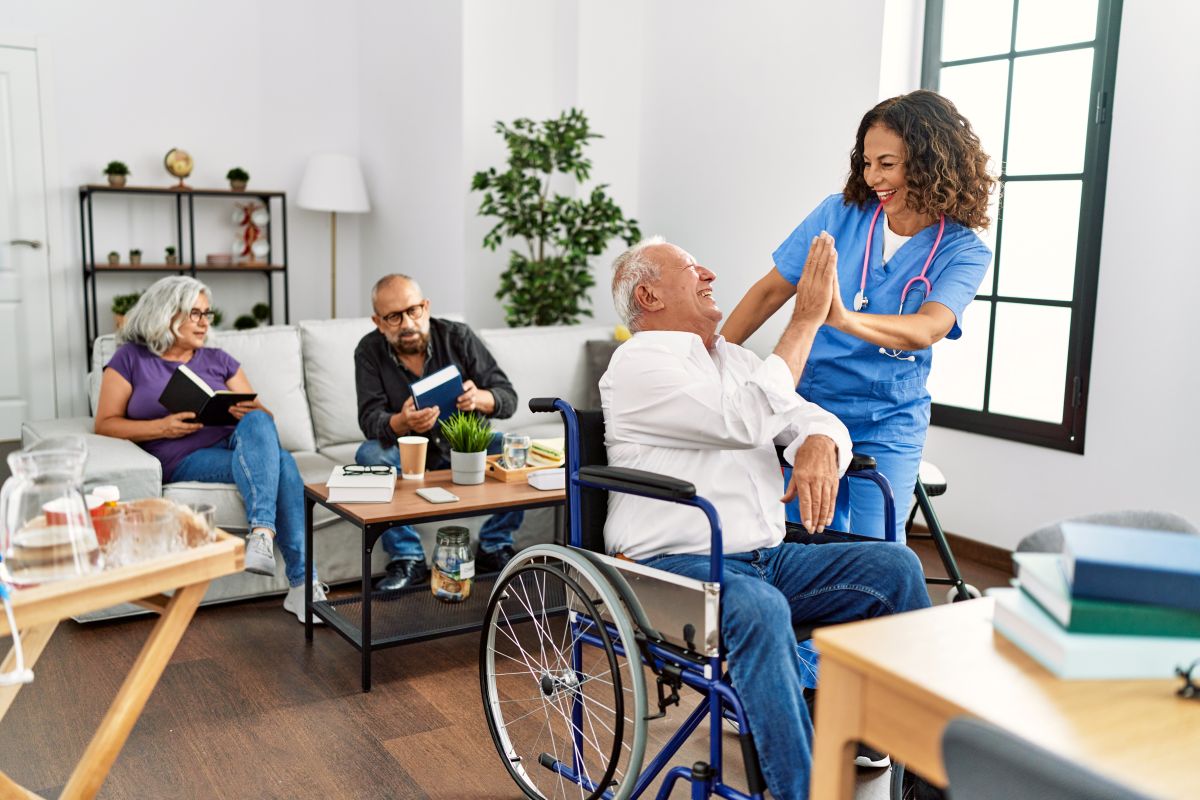 Nursing home residents relax in the lounge, along with a nurse.