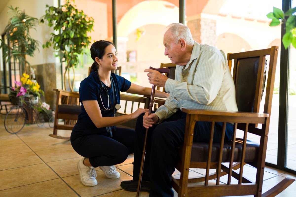 A nurse stops to chat with a nursing home resident.