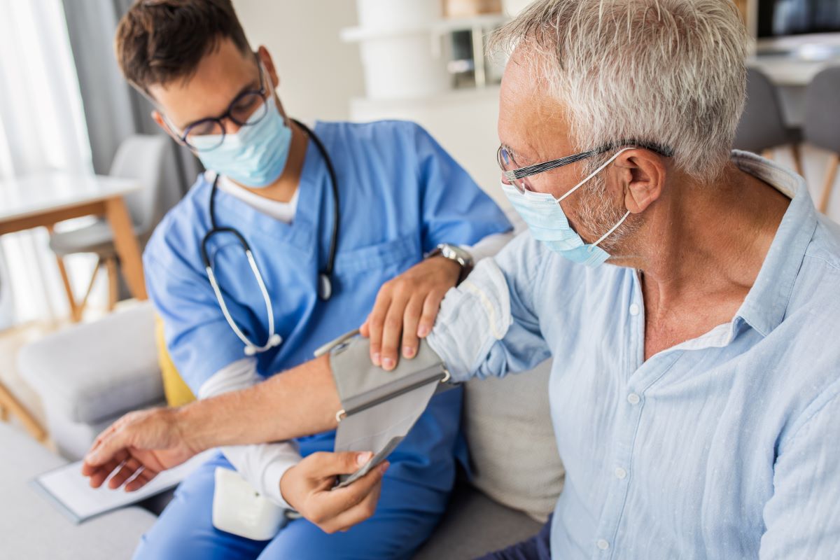 A nurse puts a supportive brace on a patient's arm.