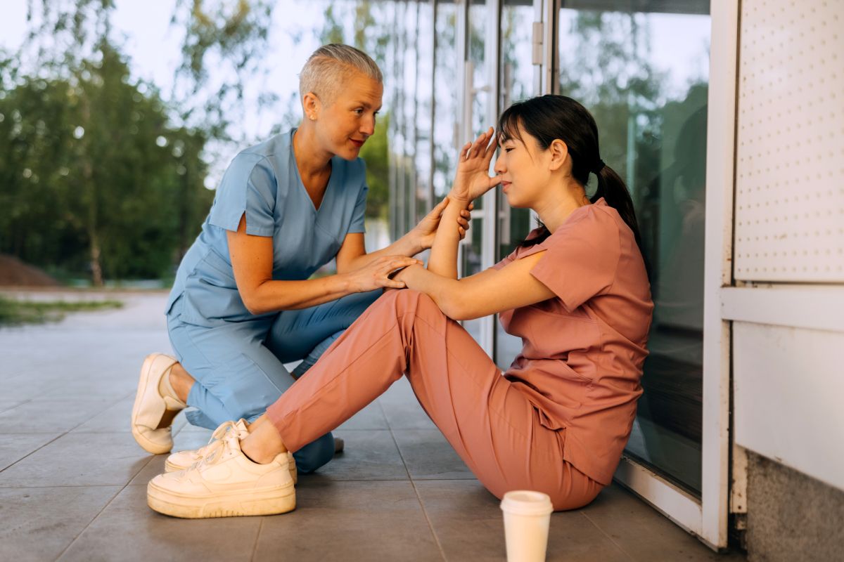 An occupational health nurse consoles a nurse working at her facility.