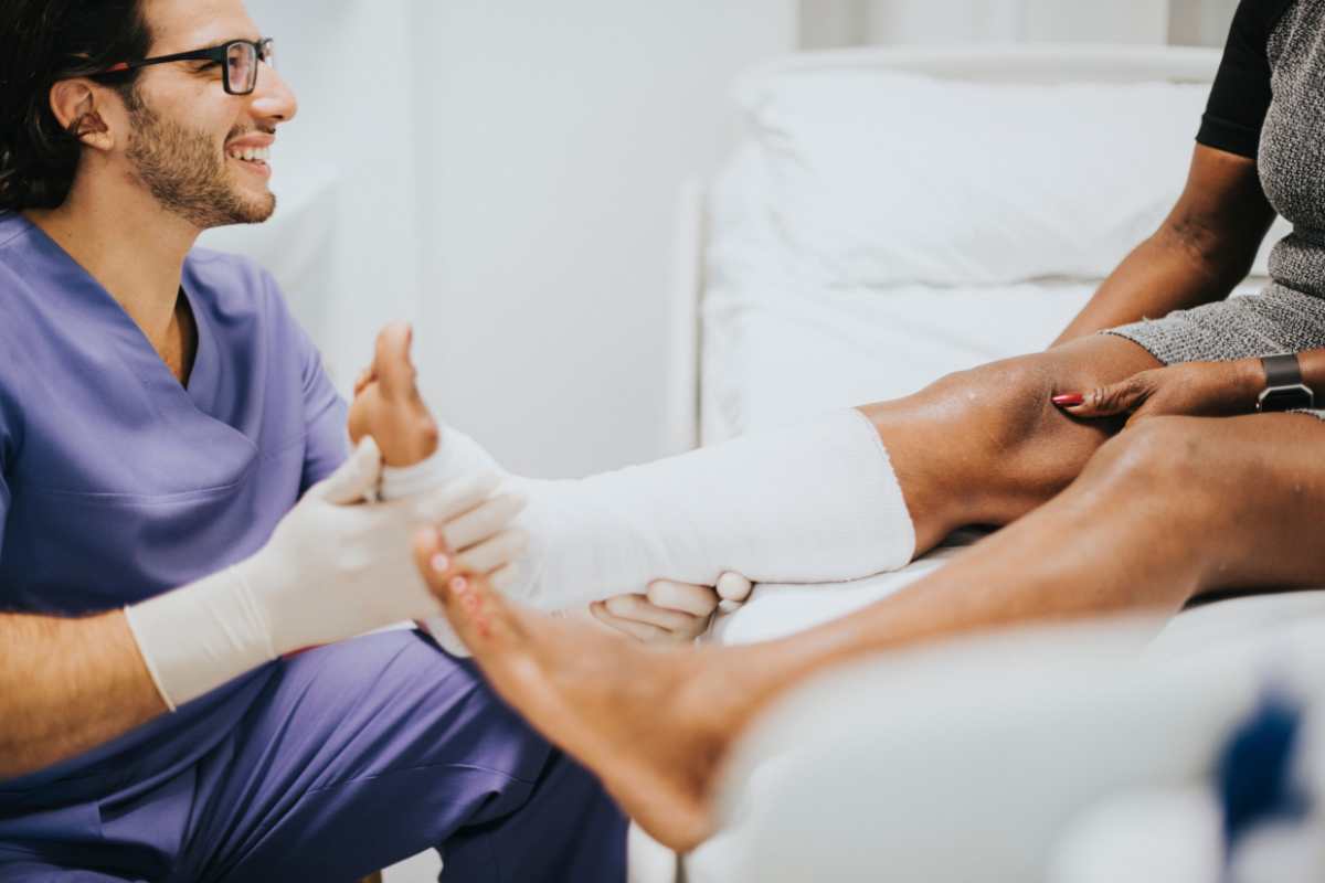 An orthopedic nurse wrapping the foot of a patient.
