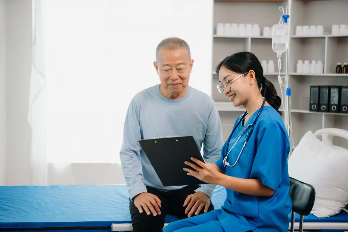 Nurse explaining a chart in her hand to an elderly patient.