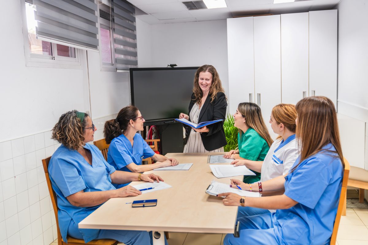 A patient care coordinator meets with nurses.