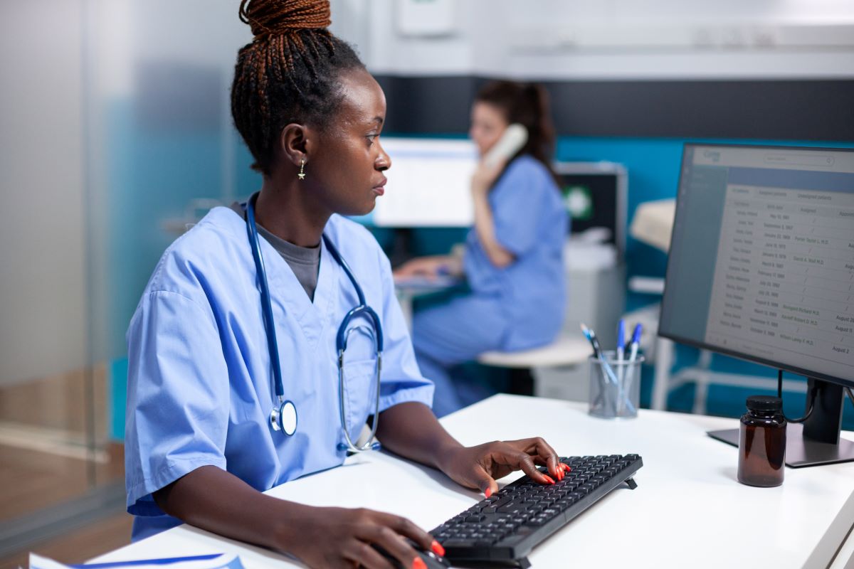 A healthcare administrator looks up sensitive patient data on a computer.