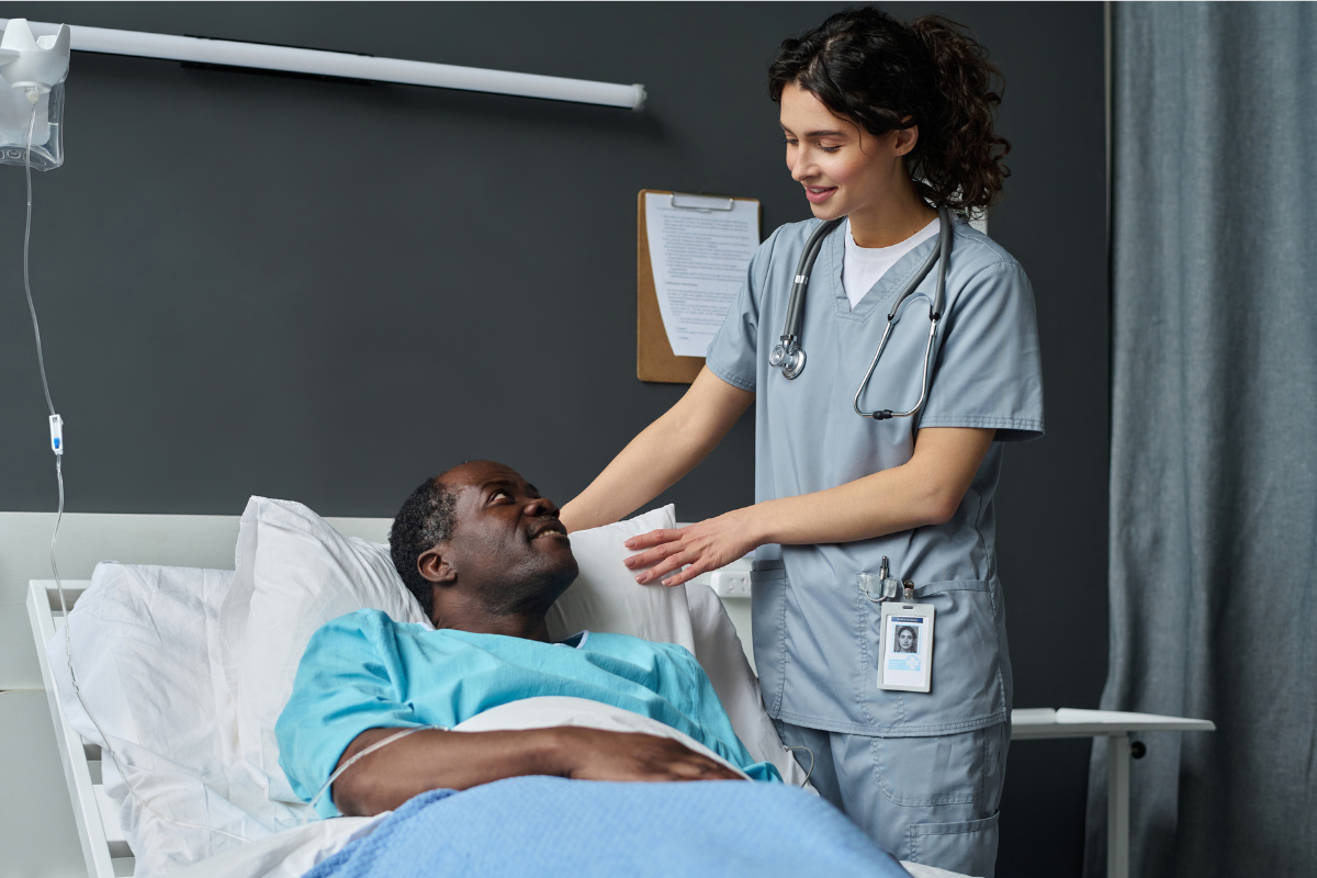 A nurse adjust patient positioning in a hospital bed.