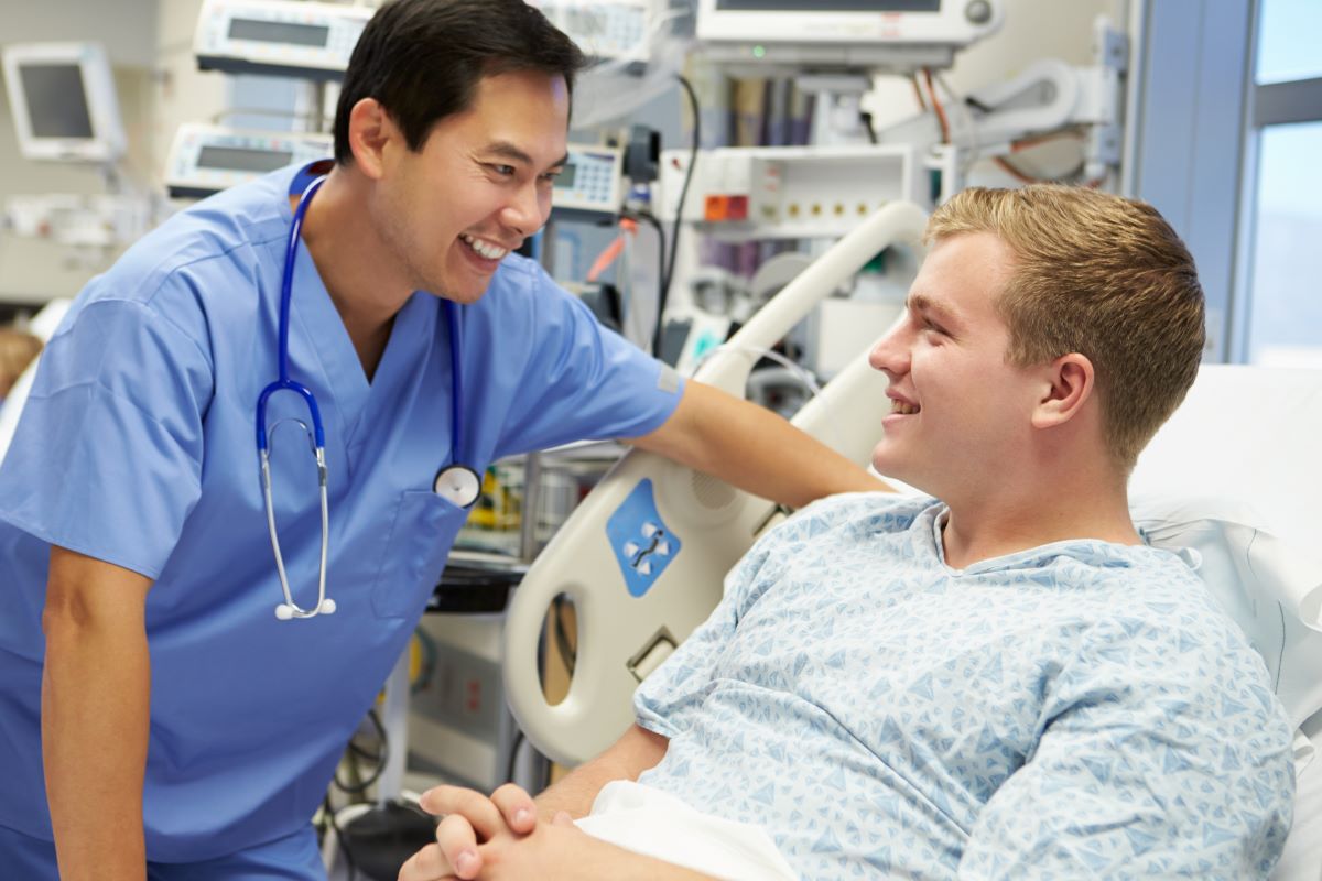 A PCU nurse talks with one of his patients.