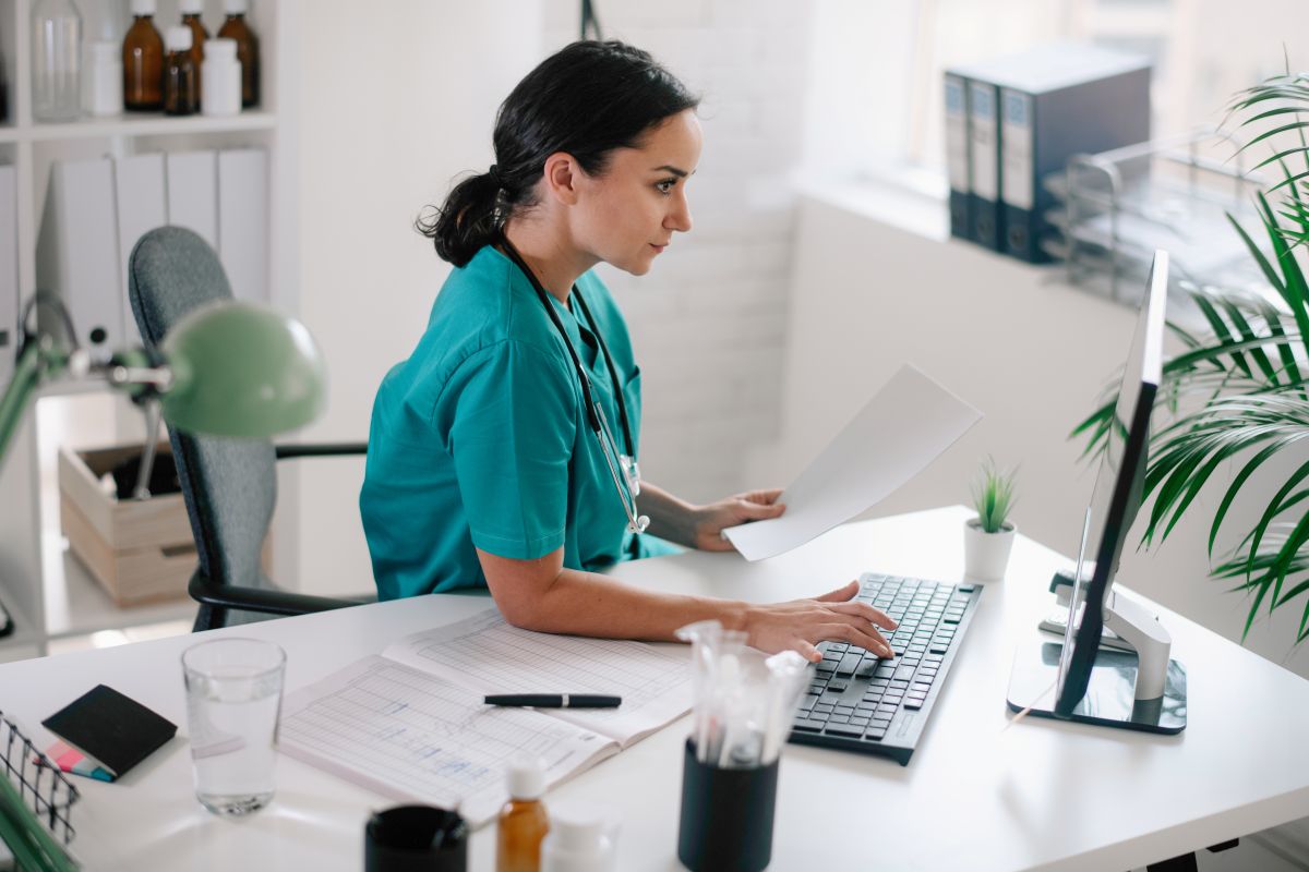 A nurse complete PECOS enrollment on the computer.