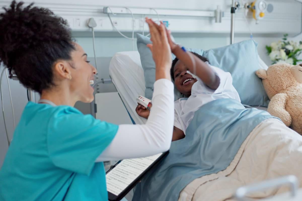 A pediatric ER nurse high-fives a patient.