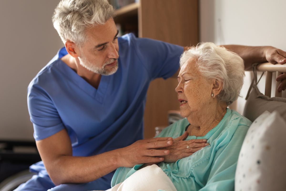 A nurse comforts a patient who is experiencing some pain.