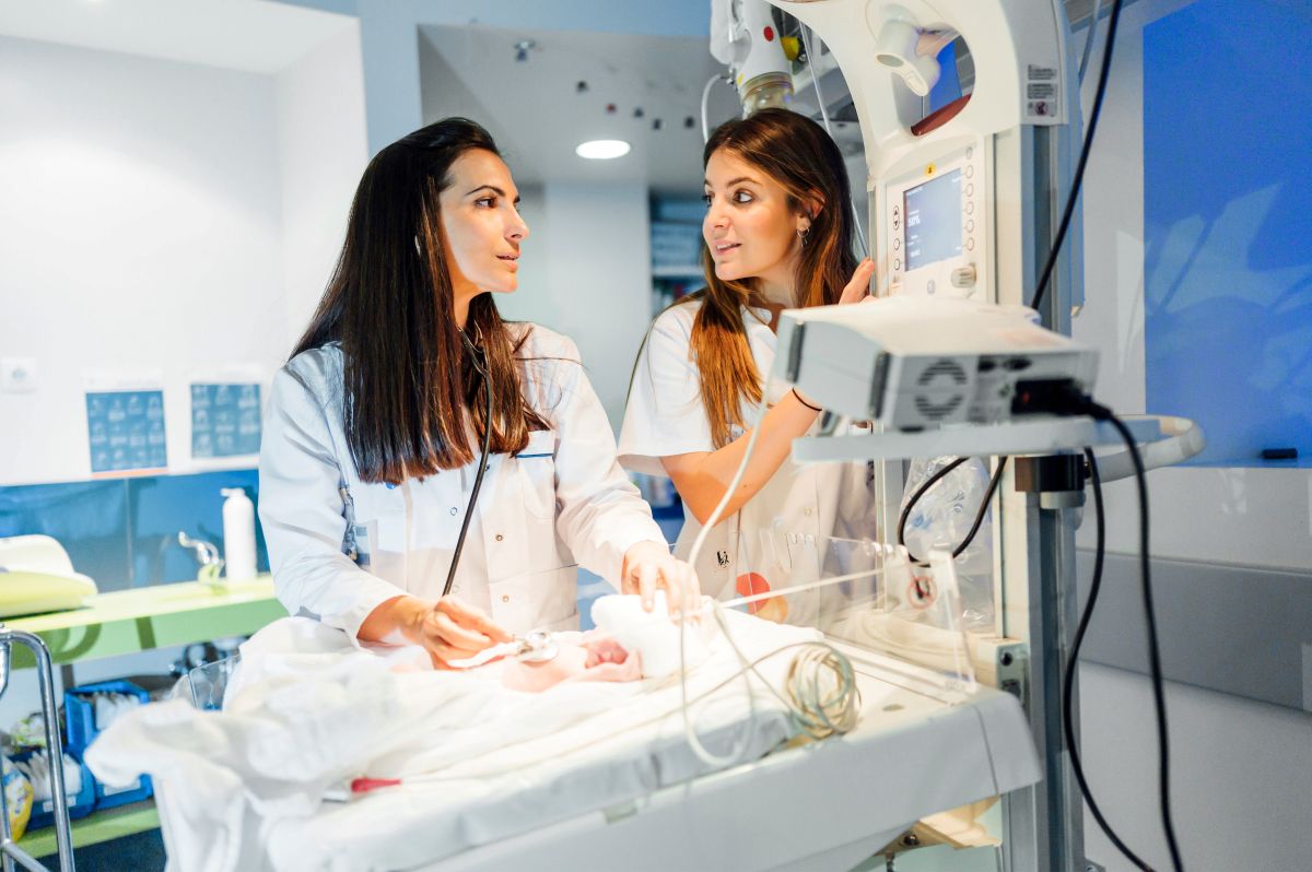 Two PICU nurses check on an infant.
